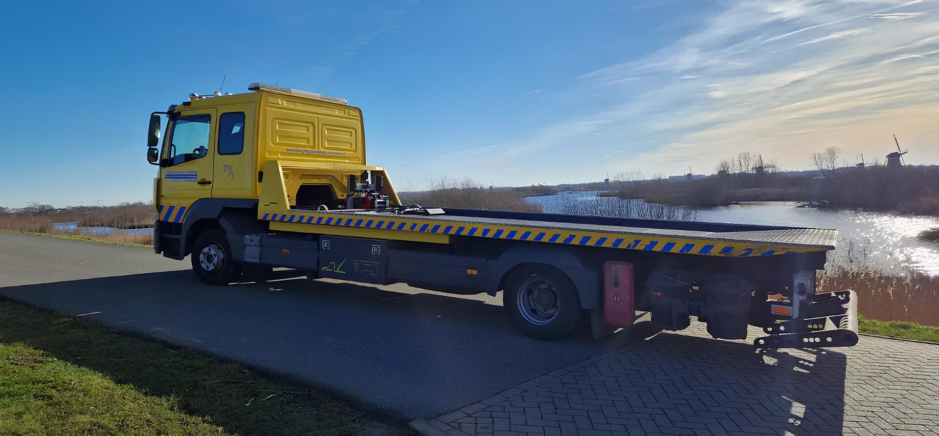 Gele oprijwagen van Bergings Centrale Drechtsteden langs het water