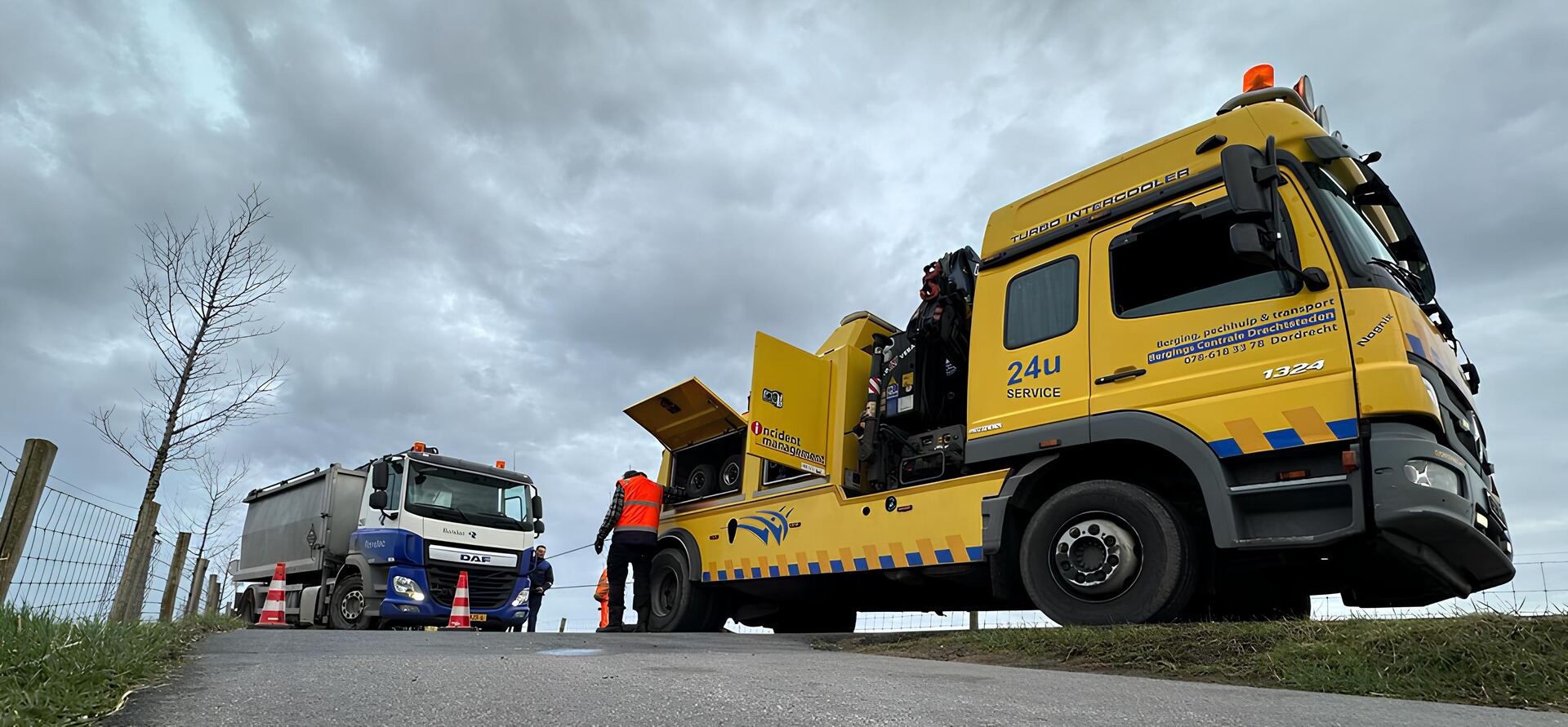 Bergers aan het werk met een bergingswagen langs de weg