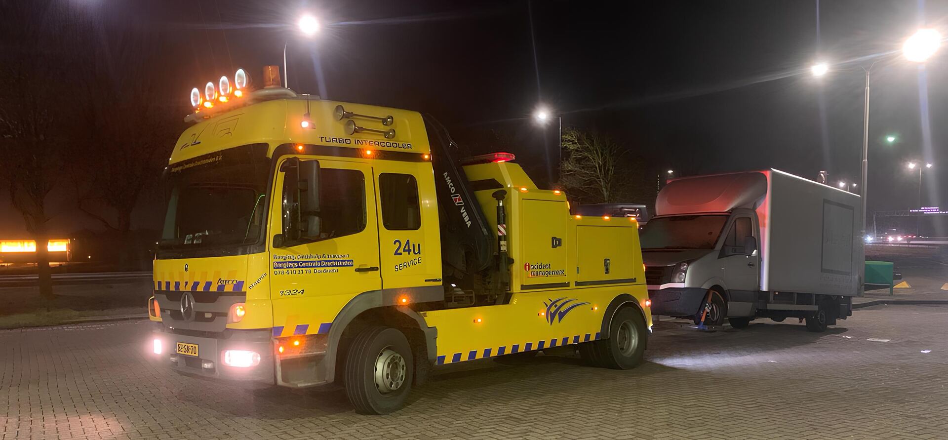 Bergingswagen met verlichting aan in de nacht